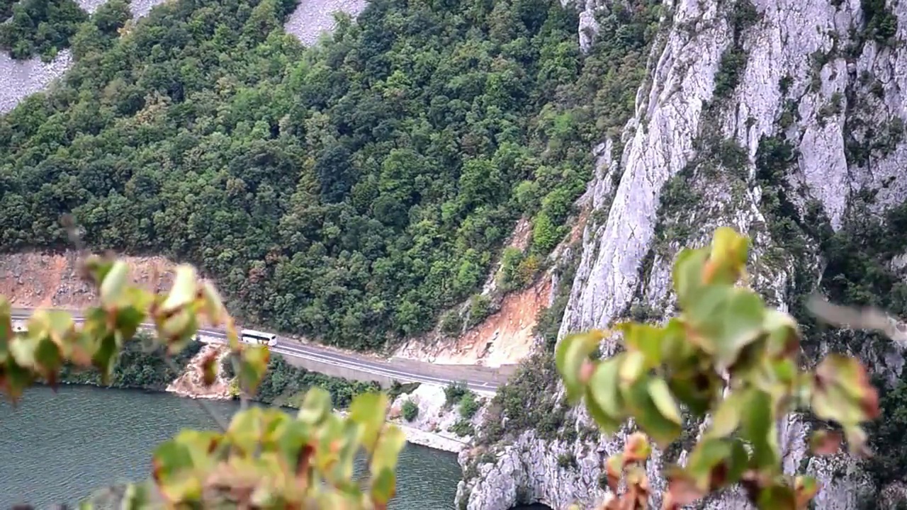 在河边沟壑中修建的公路上行驶的公共汽车视频素材