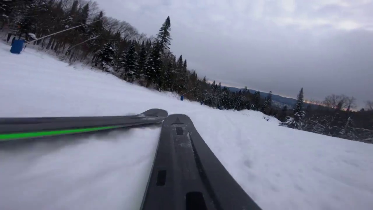 在山上的雪坡上滑雪，滑雪POV。动作摄像机的视频男子滑雪下山有乐趣的第一个轨道上的斜坡在蒙特Tremblant，魁北克，加拿大。冬季运动和活动。视频素材