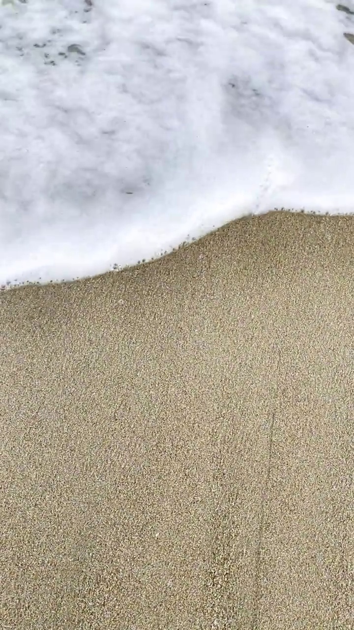 近距离拍摄的浪花卷起白色的沙滩视频素材