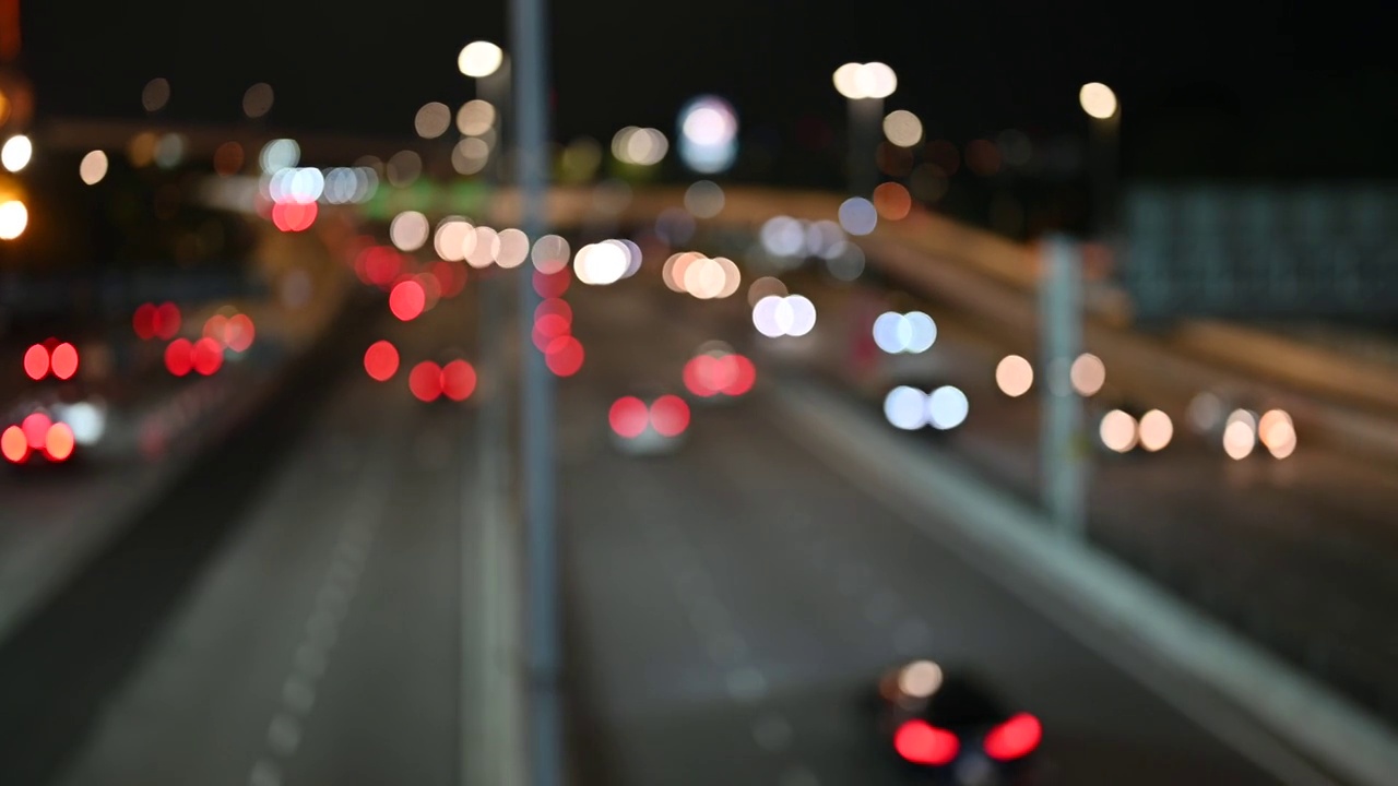 夜晚的路灯模糊了路上车辆的散景视频素材