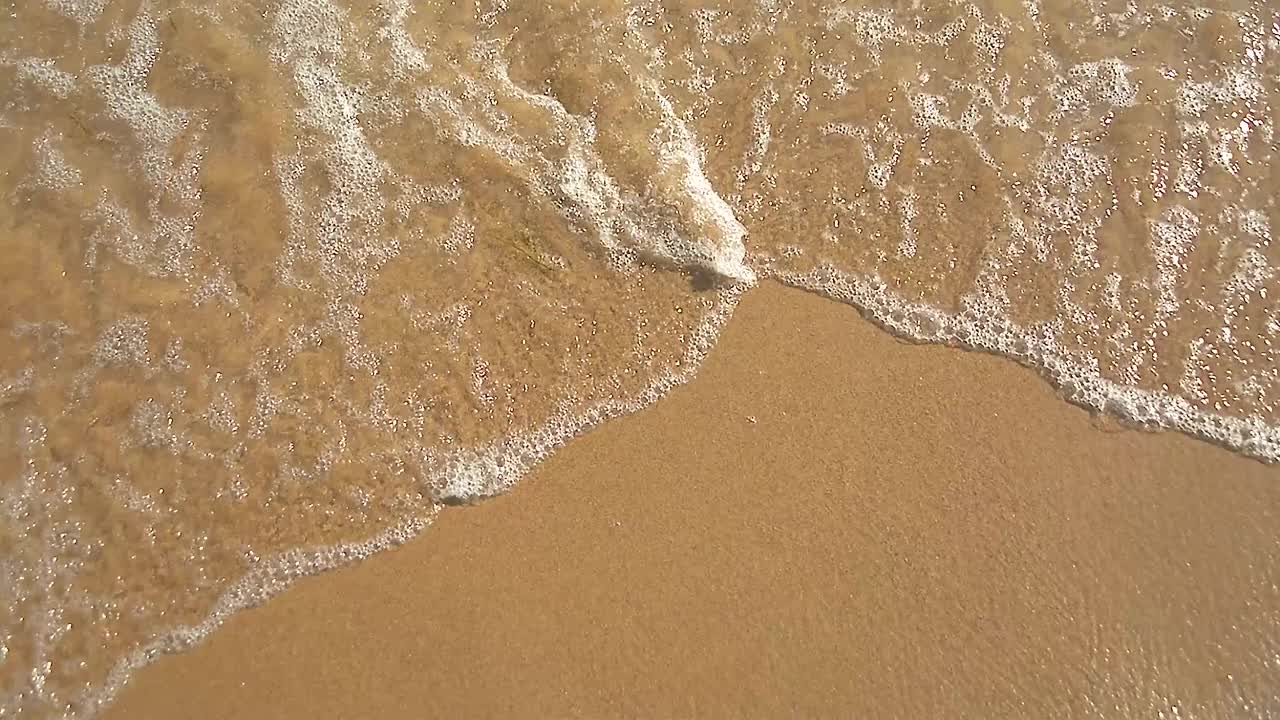 夏日海岸线上的波浪。视频素材