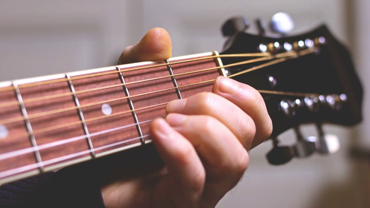 男人弹吉他，手握琴弦视频素材