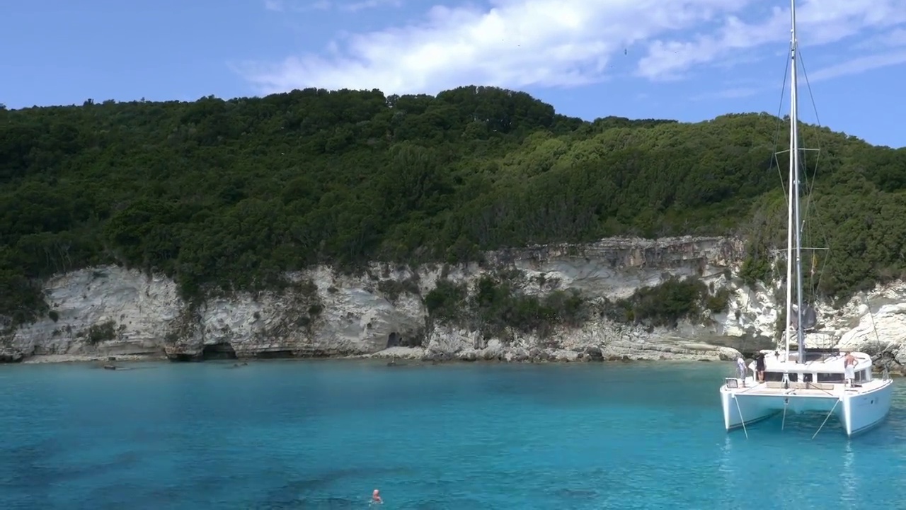 有蓝色海水和白色岩石的拉古那岛，停泊着一艘双体船视频素材