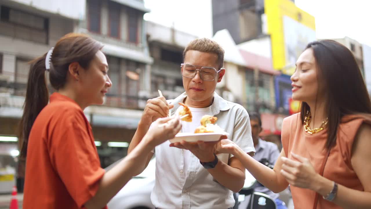 4K群亚洲人朋友一起走在唐人街一起吃街头小吃视频素材