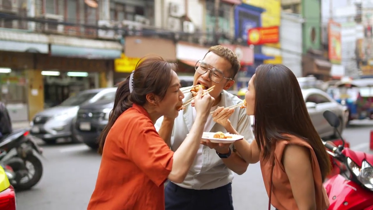 4K群亚洲人朋友一起走在唐人街一起吃街头小吃视频素材