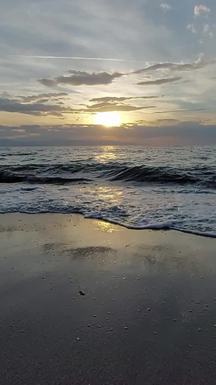 日落时分，柔和的海浪拍打着海滩视频素材