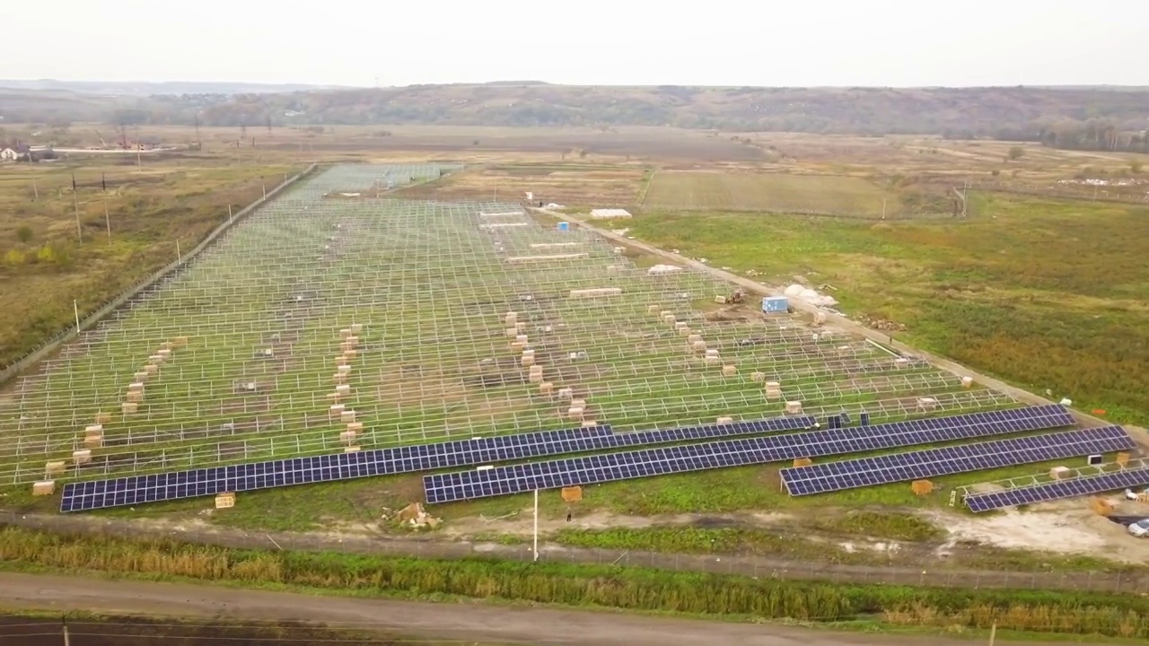 在绿地上建造太阳能发电厂的鸟瞰图。生产清洁生态能源的电板装配视频素材