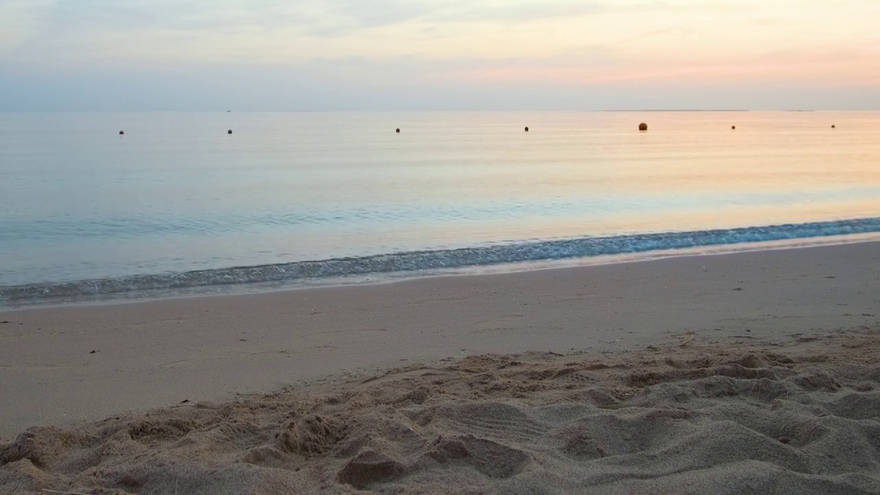 平静的海岸，在日出时，海浪拍打着沙滩视频素材