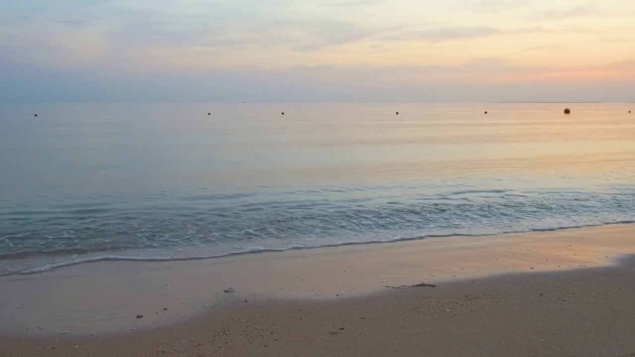 平静的海岸，在日出时，海浪拍打着沙滩视频素材