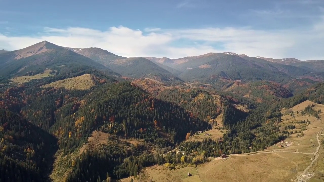 鸟瞰秋日的山景，长青的松树和黄色的秋天森林，远处有神奇的山脉。视频素材