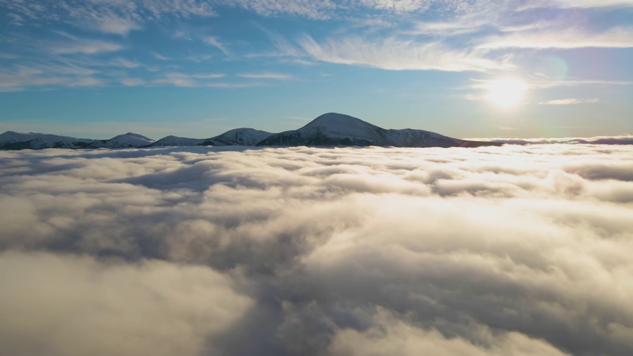 从空中俯瞰，充满活力的日出在白色浓密的云层上，远处的深色山脉在地平线上视频素材