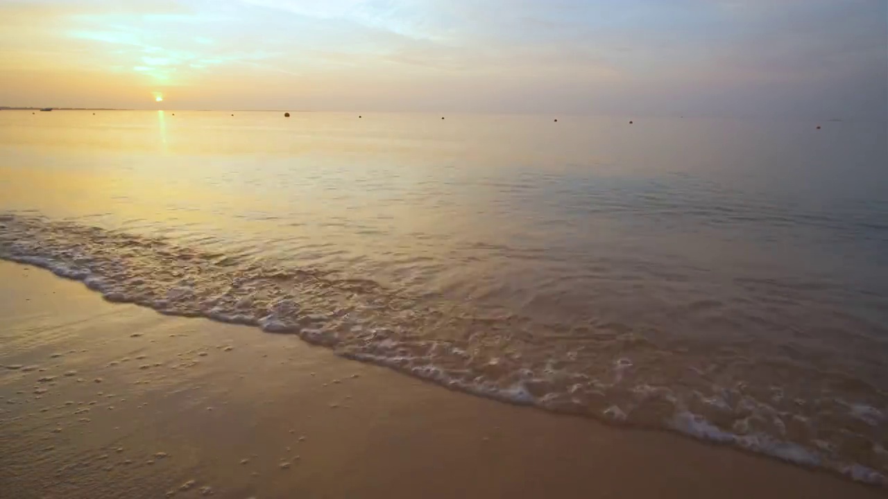 平静的海岸，在日出时，海浪拍打着沙滩视频素材