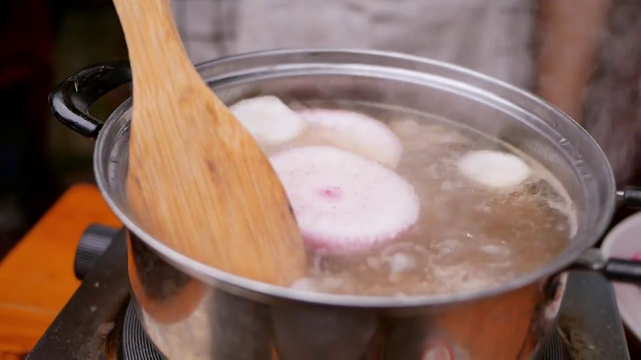 厨房电炉上的锅里煮着排骨汤。烹饪概念。视频素材