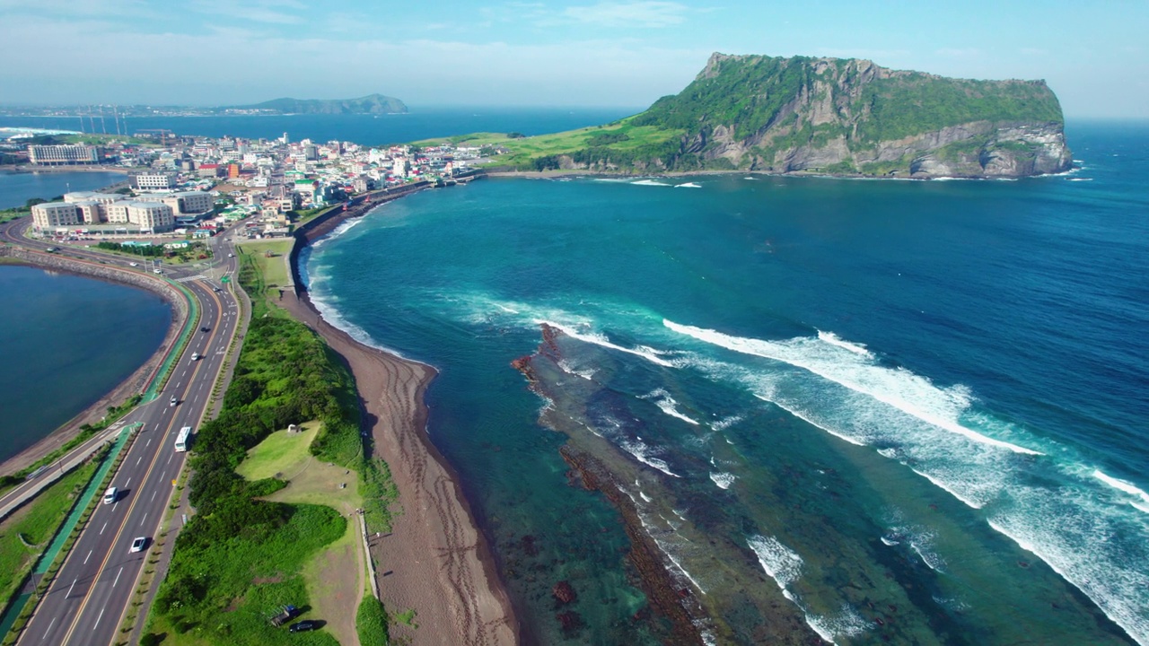 韩国济州岛圣山郡/西归浦市的圣山一秋峰凝土锥海景和广池基海滩周围的海岸公路视频素材