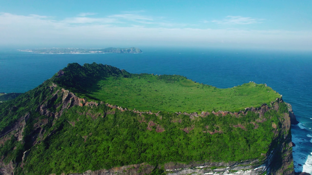 韩国济州城山郡/西归浦市的城山一秋峰凝灰岩锥，夏日的海景视频素材