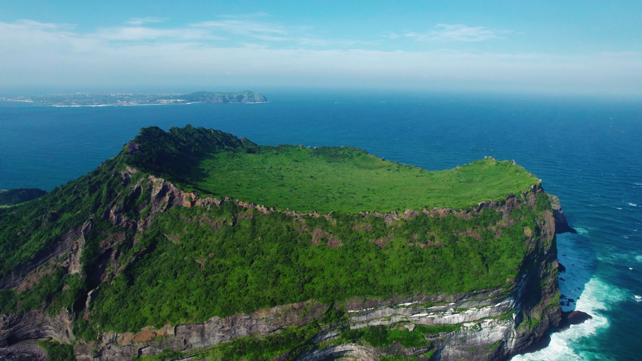 韩国济州城山郡/西归浦市的城山一秋峰凝灰岩锥，夏日的海景视频素材