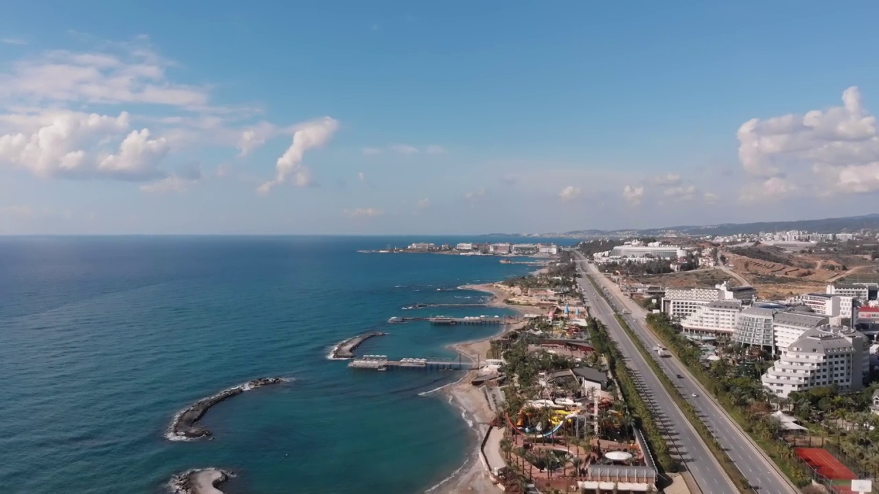 汽车驶过海岸公路，俯瞰土耳其阿兰亚湾的美景。泻湖海水碧蓝，山石嶙峋，公路繁忙。旅游及旅游概念视频素材