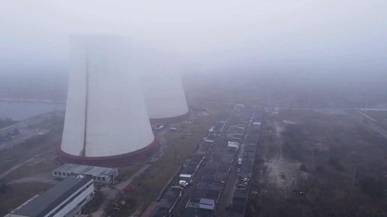 在多云大雾天气，从无人机到火力发电厂的鸟瞰图视频下载