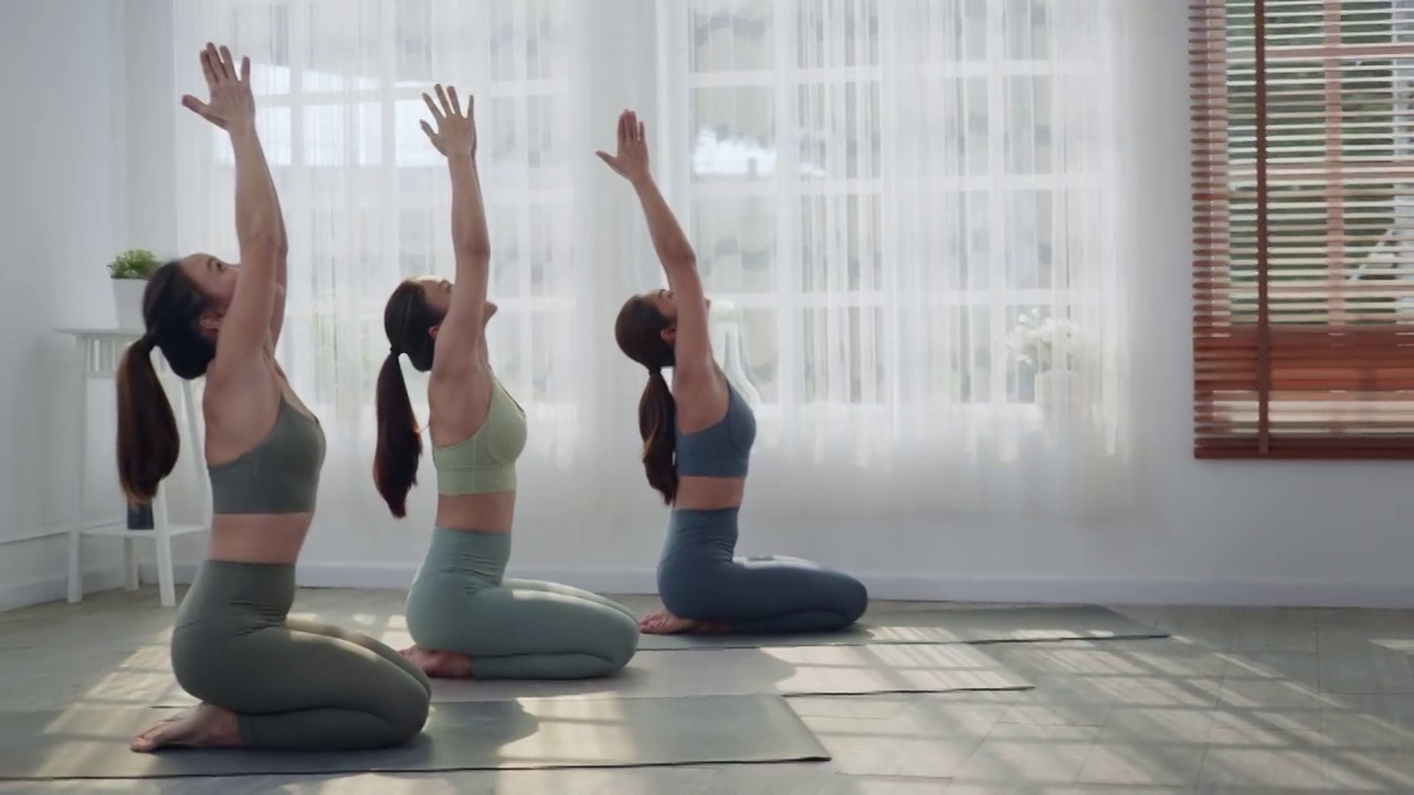 一群通过做瑜伽来学习或锻炼的亚洲妇女。视频素材