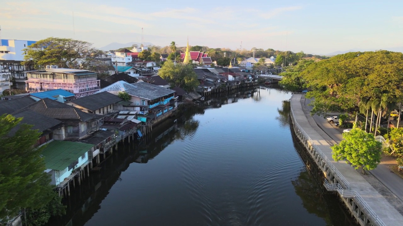 Chanthaboon滨水区(Aerial-Drone VDO) -泰国寺庙和古老的木制房屋，在日落时沿着河岸的游船旅行。视频素材