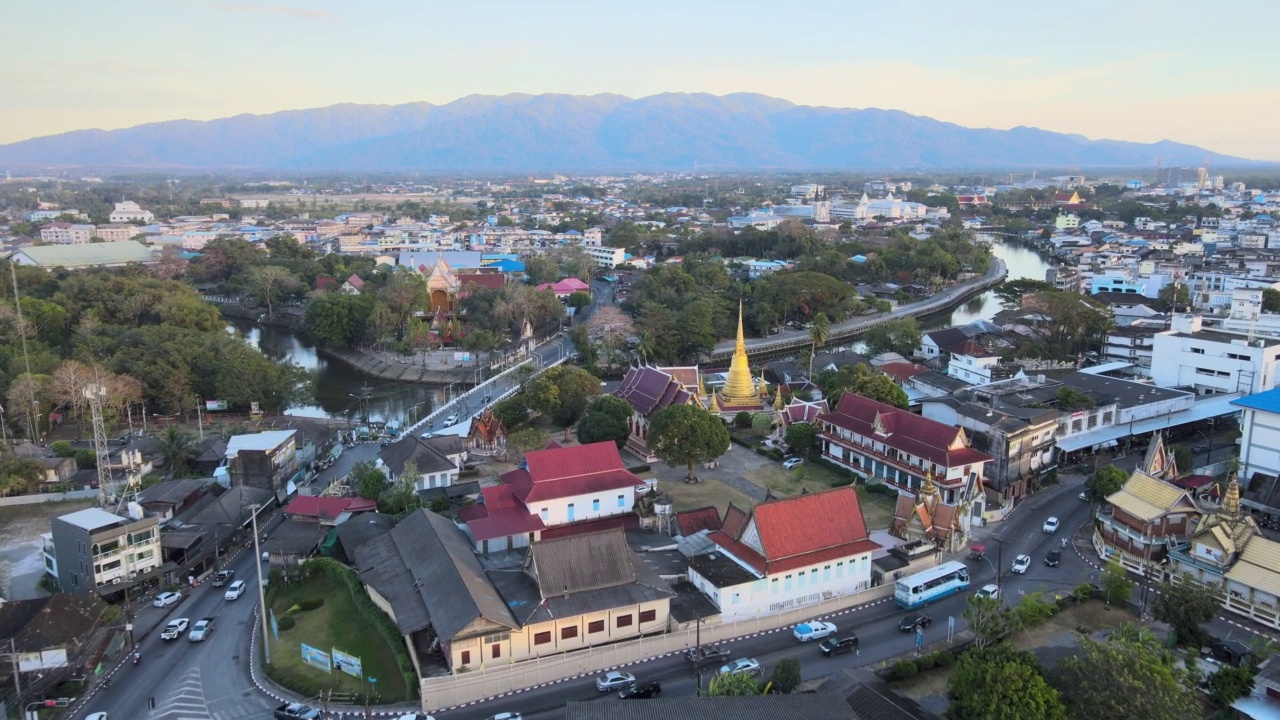 Chanthaboon滨水区(Aerial-Drone VDO) -日落时分沿河的泰国寺庙和古老的木屋。视频素材