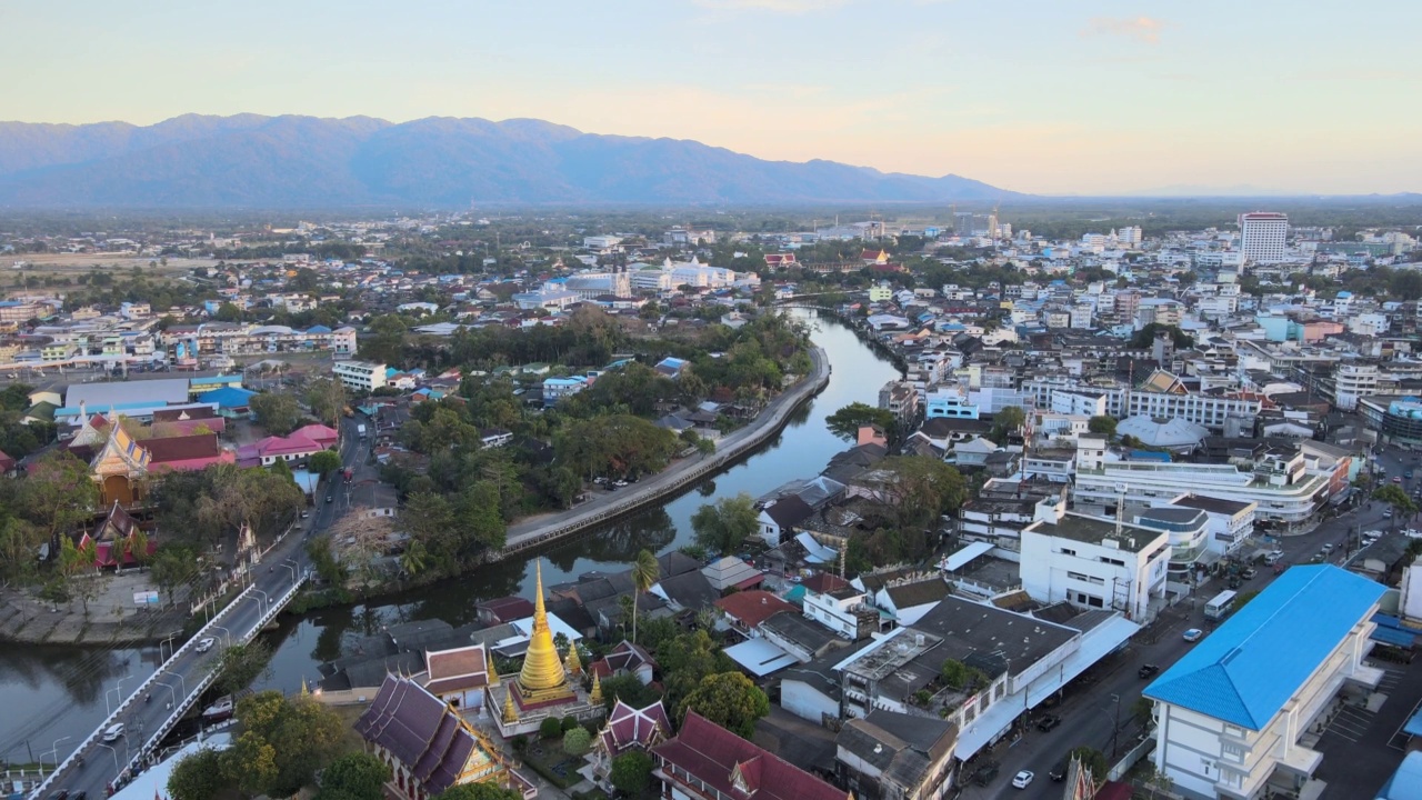 Chanthaboon滨水区(Aerial-Drone VDO) -日落时分沿河的泰国寺庙和古老的木屋。视频素材