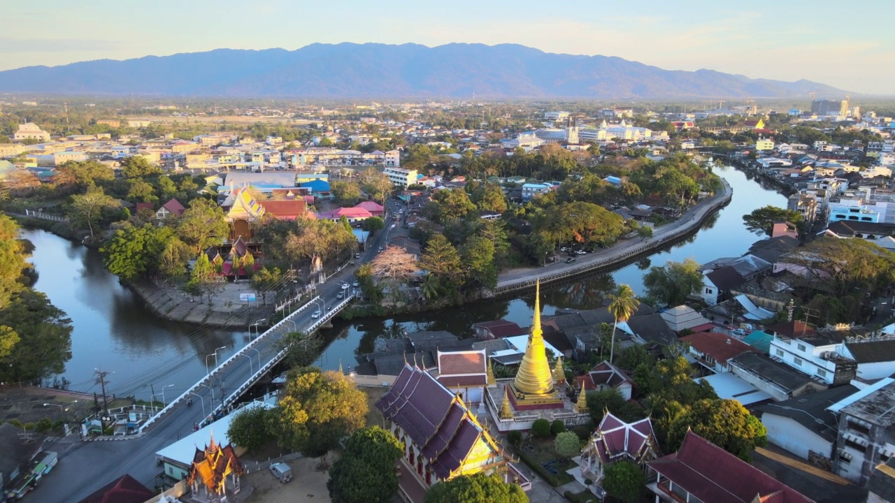 Chanthaboon滨水区(Aerial-Drone VDO) -日落时分沿河的泰国寺庙和古老的木屋。视频素材