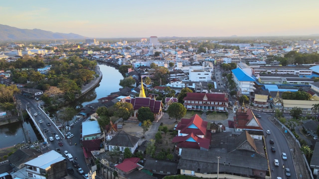 Chanthaboon滨水区(Aerial-Drone VDO) -日落时分沿河的泰国寺庙和古老的木屋。视频素材