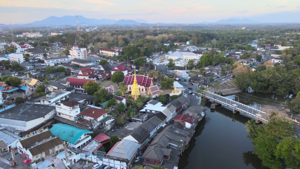 Chanthaboon滨水区(Aerial-Drone VDO) -日落时分沿河的泰国寺庙和古老的木屋。视频素材