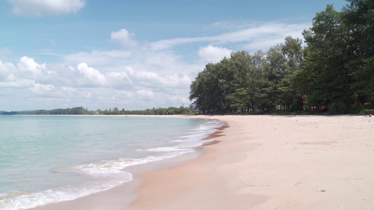 风和日丽的热带沙滩上，海浪拍打着沙滩。复制提供了空间。海景和云雾的天空。视频素材