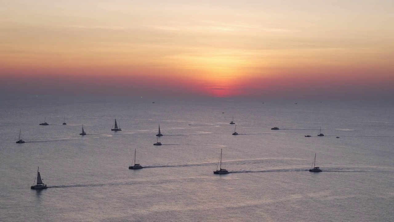 从旅游摄影角度拍摄日落黄昏时的全景海景鸟瞰图。拍摄海角黎明日落，豪华帆船在海上航行。夏季阳光热带的氛围提供复印空间。视频素材