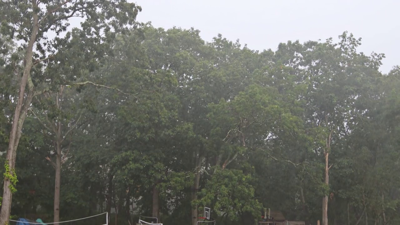 在暴雨期间，城市街道上的居民在大雨后被淹没视频素材