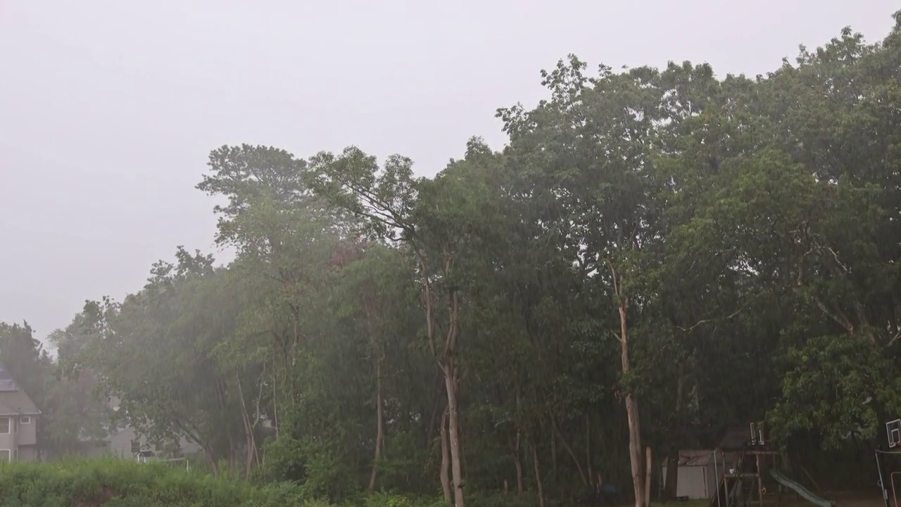 夏天的时候，大雨倾盆，从屋顶流下的雨水在镇上泛滥成灾视频素材