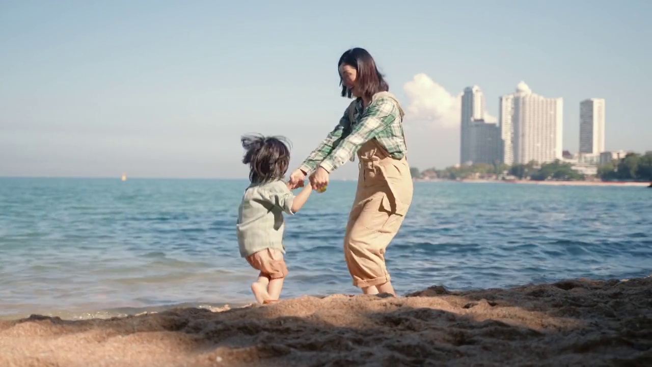 亚洲家庭海滩度假，快乐的亚洲家庭玩，在海滩上有乐趣视频素材