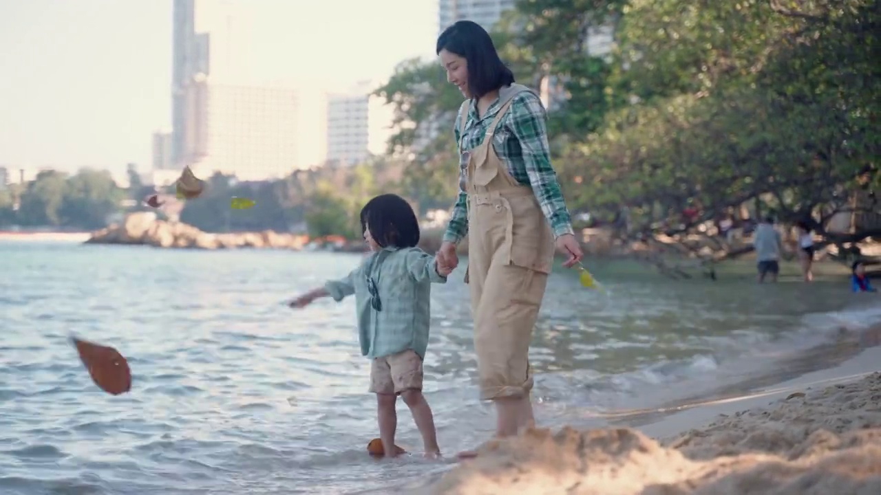 亚洲家庭海滩度假，快乐的亚洲家庭玩，在海滩上有乐趣视频素材