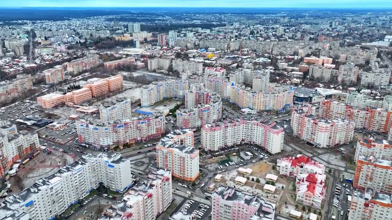 居民区有大片的公寓、道路和汽车。耸立在大城市的美丽景点之上。冬季灰色天空背景下的城市景观和自然。视频素材