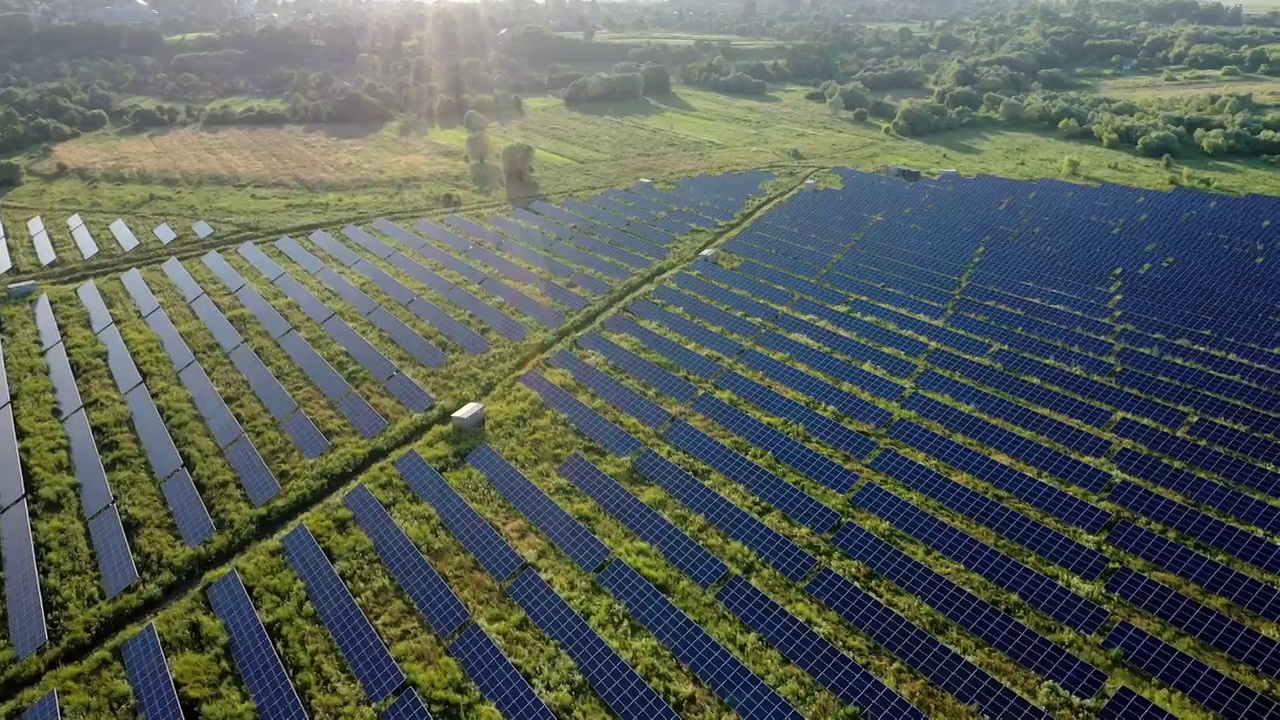 俯视图，一个巨大的光伏电站位于日落的田野。太阳能发电厂。生态清洁能源。选择太阳能站。视频素材