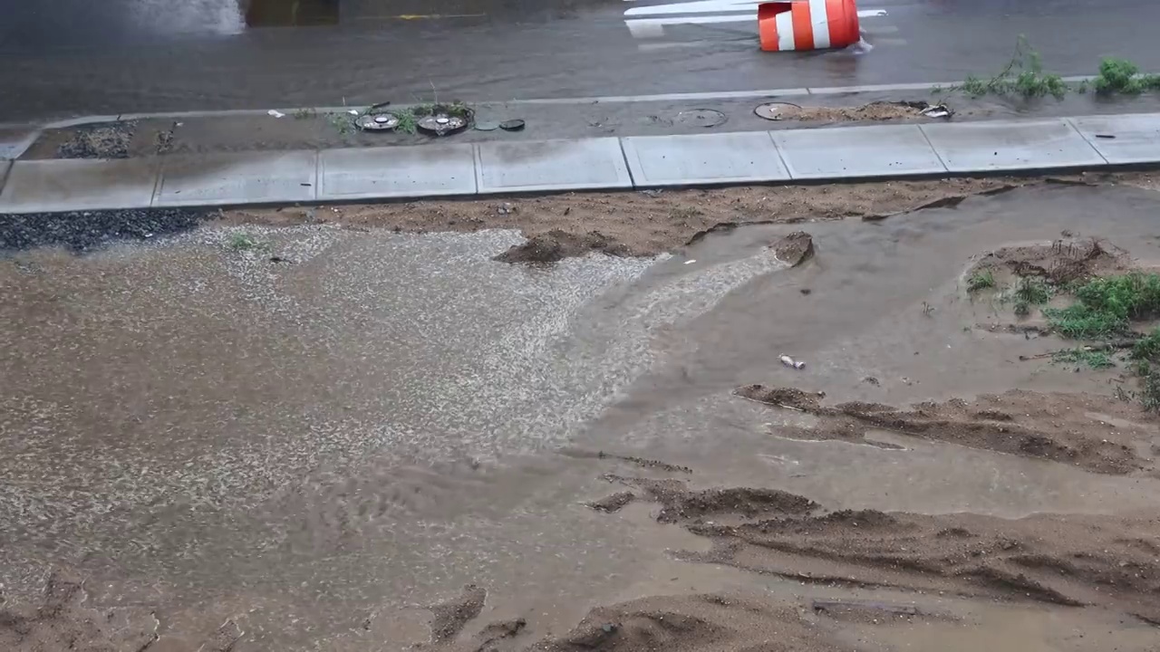 马路上的脏水坑在水流雷雨时排空马路上的水视频素材