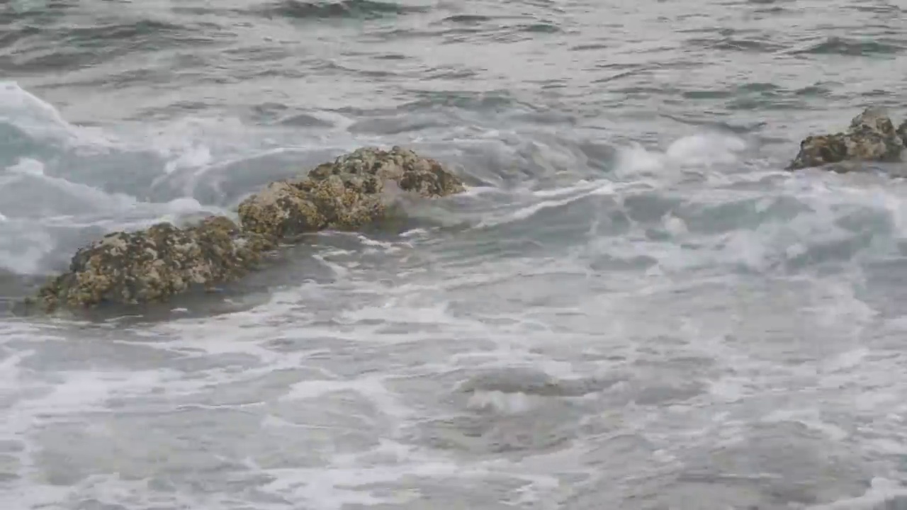 海浪拍打着淹没的岩石视频素材