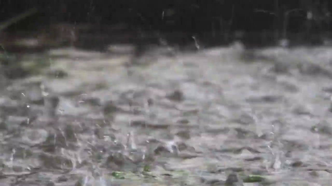 在暴雨倾盆的时候，在球场中间溅起水坑跳起视频素材