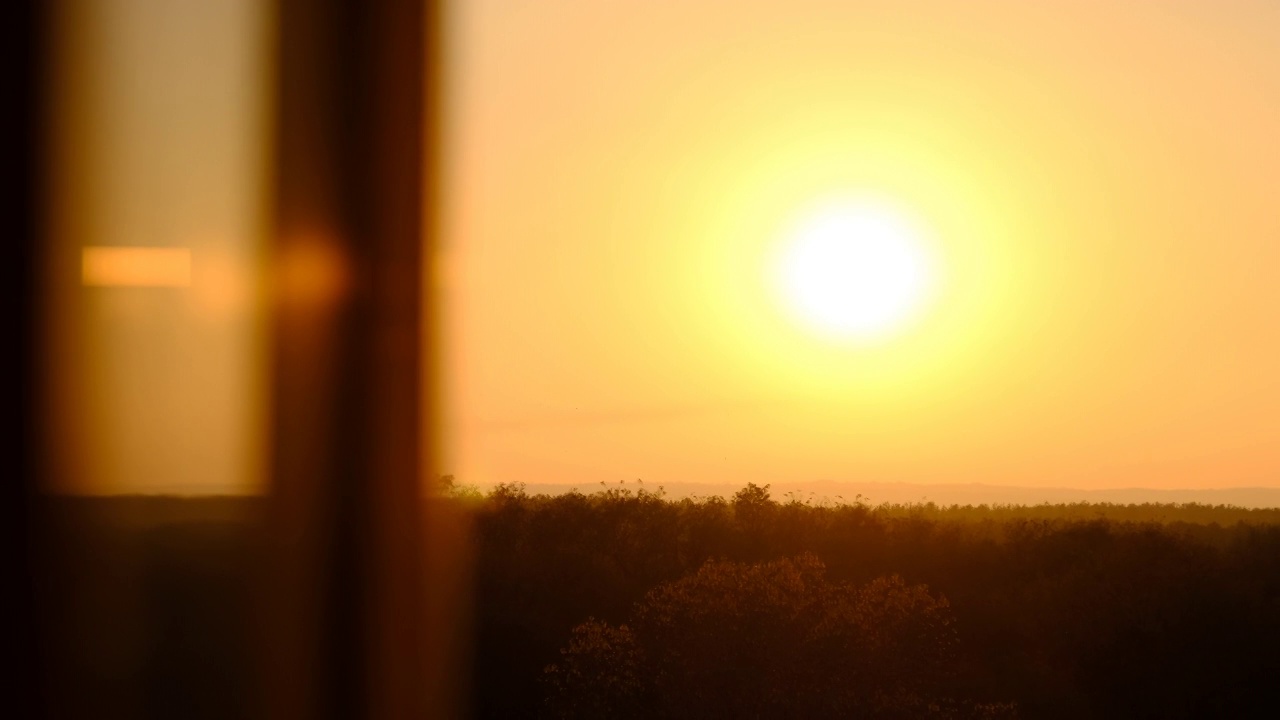 地平线上的夕阳，窗外的剪影视频素材