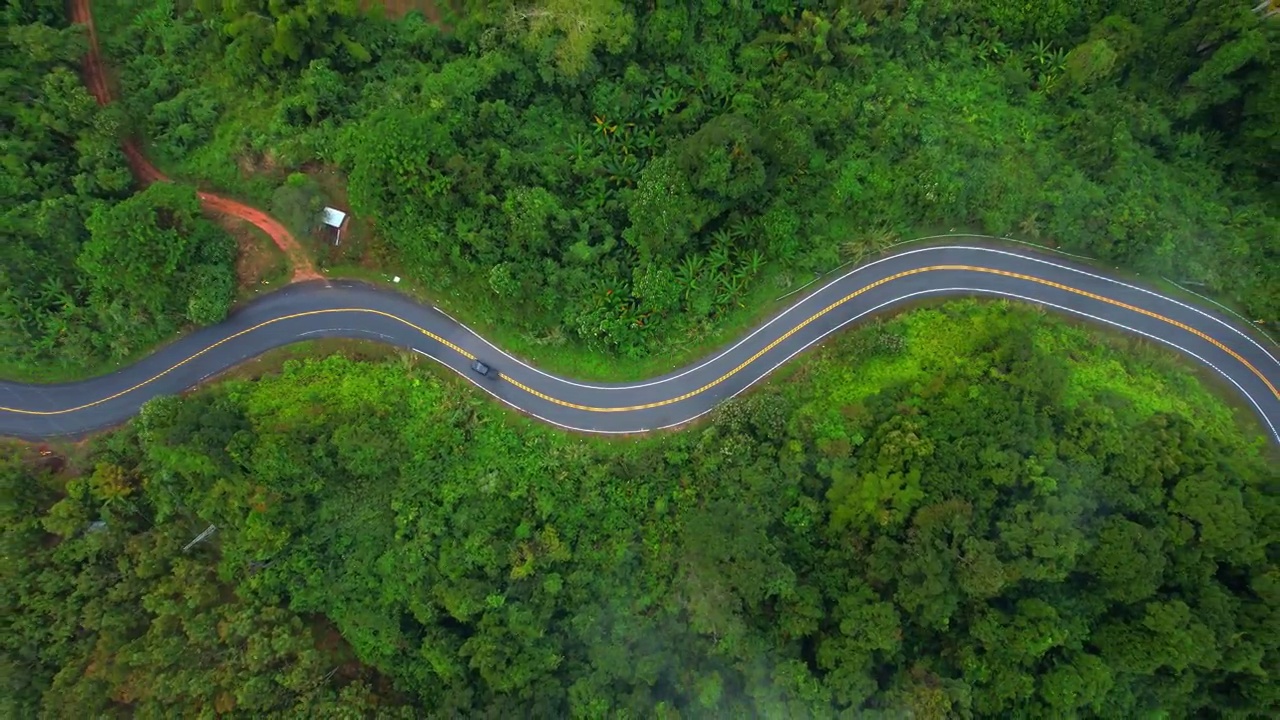 鸟瞰泰国热带森林中蜿蜒的山路。视频素材