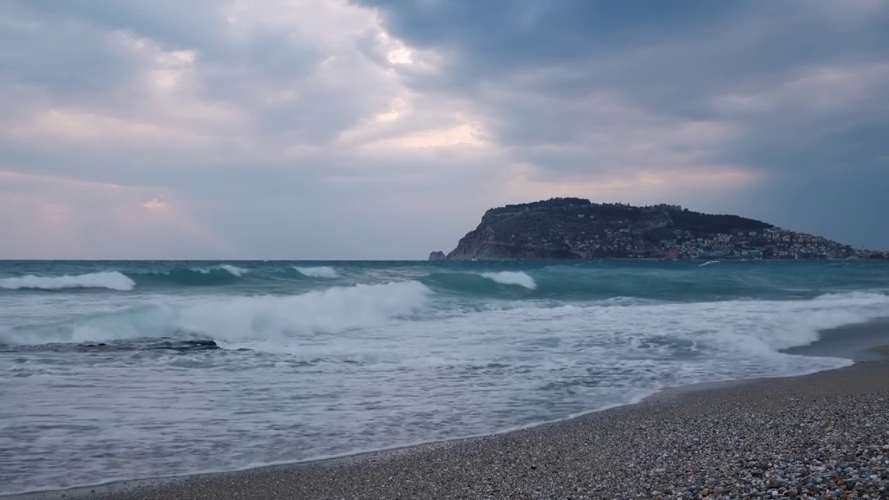 在海上风暴。海浪拍打着沙滩和卵石滩。美丽的海景度假城市阿兰亚，土耳其。神奇的自然景观视频素材