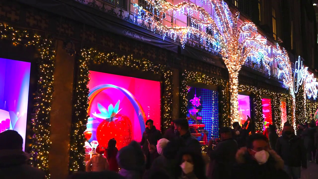 人们在圣诞之夜观看萨克斯第五大道(Saks Fifth Avenue)的节日展示视频素材