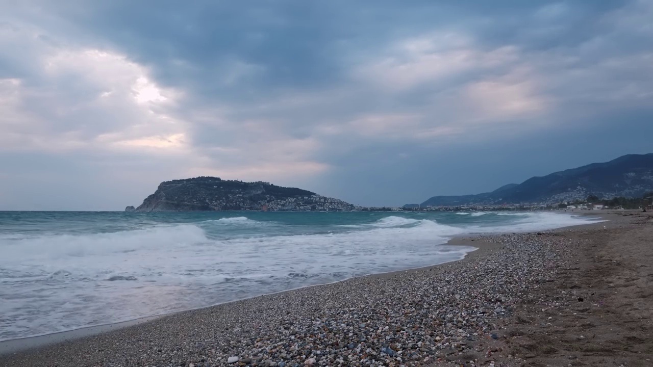 海浪拍打着海滩。多云暴风雨天的热带海滩。令人惊叹的海滩，沙滩和巨大的海浪。Alanya、土耳其视频素材