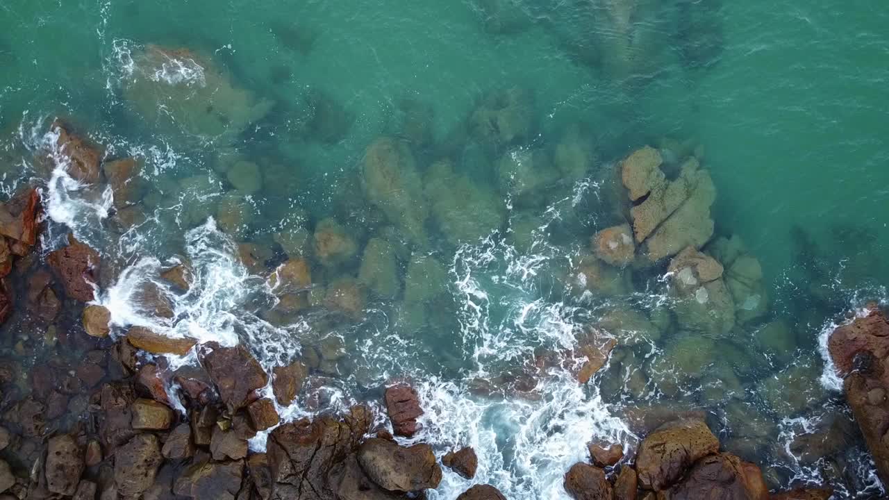 随着第一缕晨光，海浪拍打着坎塔布里安的岩石。视频素材