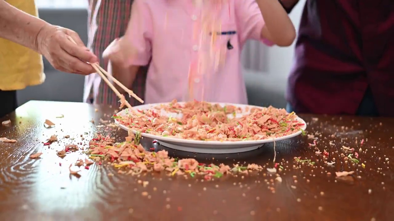 快乐微笑的多代亚裔华人家庭在中国新年庆祝活动中抛生鱼菜肴怡生视频素材