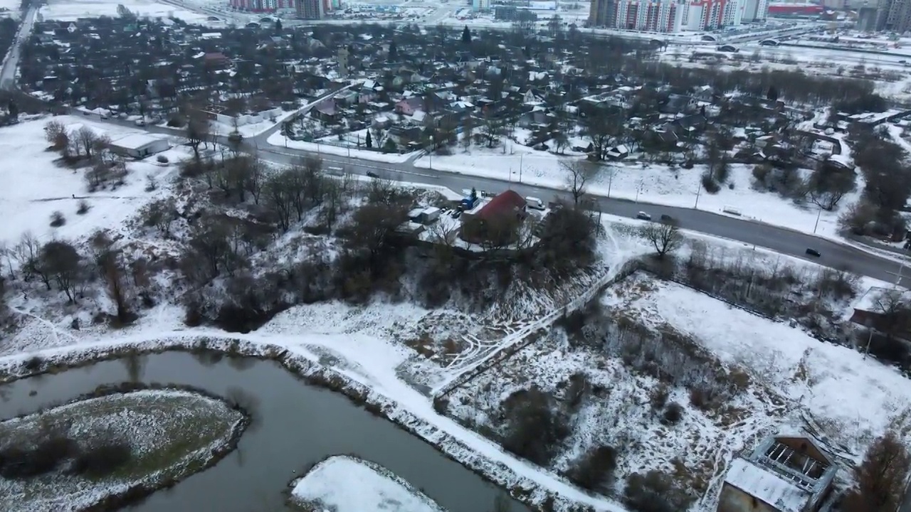 在白雪覆盖的城市公园里，在河上飞行。航空摄影。视频素材