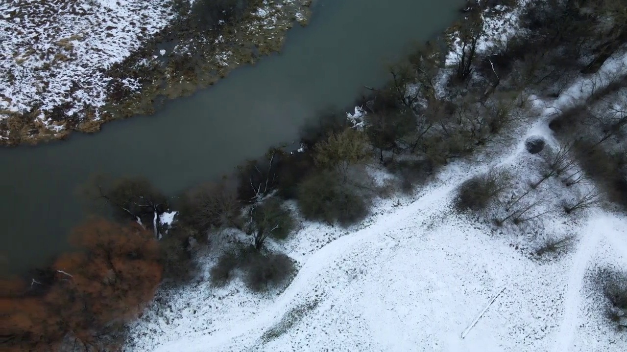 在白雪覆盖的城市公园里，在河上飞行。航空摄影。视频素材