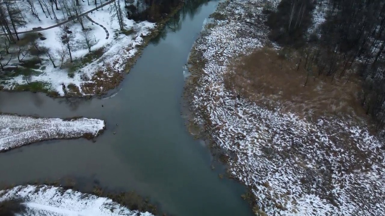 在白雪覆盖的城市公园里，在河上飞行。航空摄影。视频素材